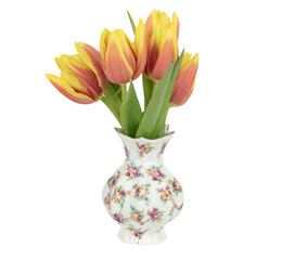 Blumenstrauß aus gelb-roten Tulpen in einer kleinen, geblümten, alten Vase, freigestellt, isoliert