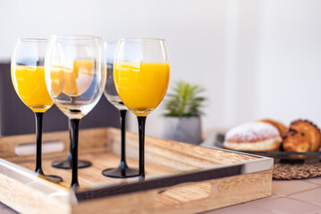Delicious Breakfast Setting Featuring Fresh Orange Juice, Croissants, and Donut on a Stylish Outdoor Table Arrangement for a Relaxing Start to the Day