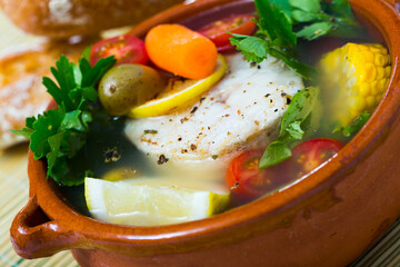 Recipe of pottage of fisherman: boil merluccius head for broth. Add potatoes, carrots, shallots, corn, fish steak 200 g, salt, pepper. Bring to oven, cook for 40min at temperature of 200 deg
