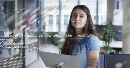 Image of digital data processing over caucasian businesswoman using laptop in office