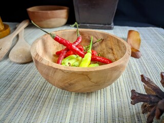 Fresh Red and Green Chili Peppers in a Wooden Bowl on a Bamboo Mat