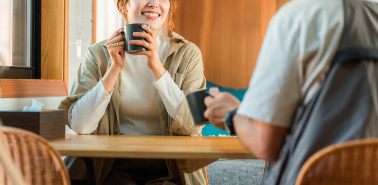 家・別荘・コテージでパソコンをやりながらコーヒーを飲む夫婦・カップル・男女(話す・会話)
