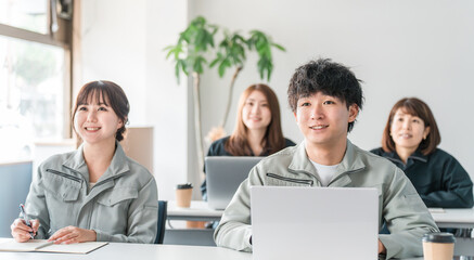 会議・ミーティング・プレゼンを聞く作業着姿のビジネスマン男女
