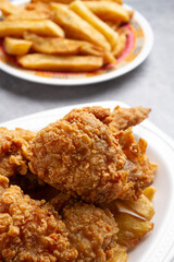 fried chicken with french fries on marble background on a white plate and Chinese dish
