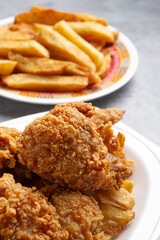 fried chicken and plate of french fries on marble background