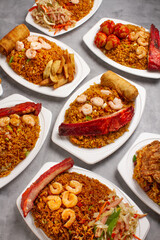 Chinese food dishes of chicken in sweet and sour sauce, fried rice, pork ribs, shrimp and spring roll