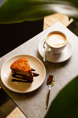 a marble cake on a plate and a cup of coffee on a table in a coffee shop