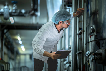 Professional worker analyzing operational data on production equipment in a state-of-the-art food factory Prioritizing efficiency and safety compliance.