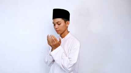 handsome asian muslim youth gesture hands raised praying with isolated white background