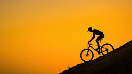 Obraz premium Passion and motivation excitement, A silhouette of a cyclist ascending a hill against a vibrant orange sunset backdrop, showcasing adventure and outdoor activity.