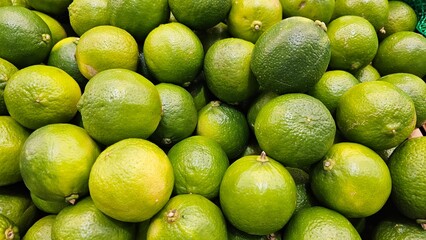 limes on the stall, fresh green limes background, many