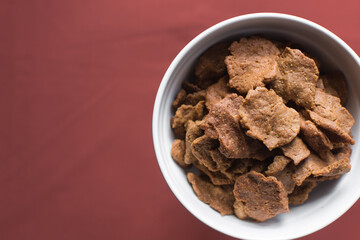 Overhead view of kuli-kuli in a white bowl, top view of nigerian groundnut cakes in a bowl