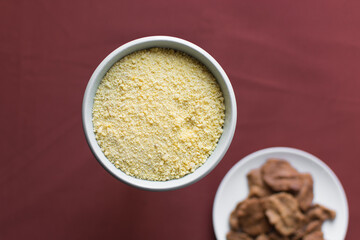 Yellow garri in a white bowl, top view of nigerian garri in a ceramic bowl, fried cassava, garri for eba