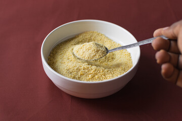 Yellow garri in a white bowl, top view of nigerian garri in a ceramic bowl, fried cassava, garri for eba