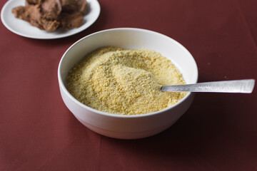 Yellow garri in a white bowl, top view of nigerian garri in a ceramic bowl, fried cassava, garri for eba