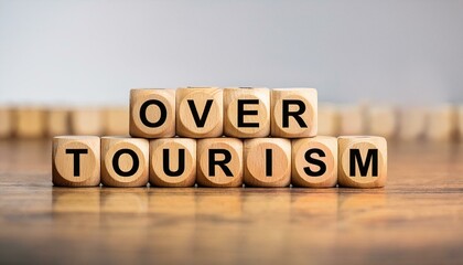 オーバーツーリズムを意味する英語のフレーズover tourismの文字が書かれたキューブブロック。 aiで生成	