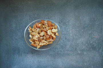 top view of many mixed nuts in a bowl on table 