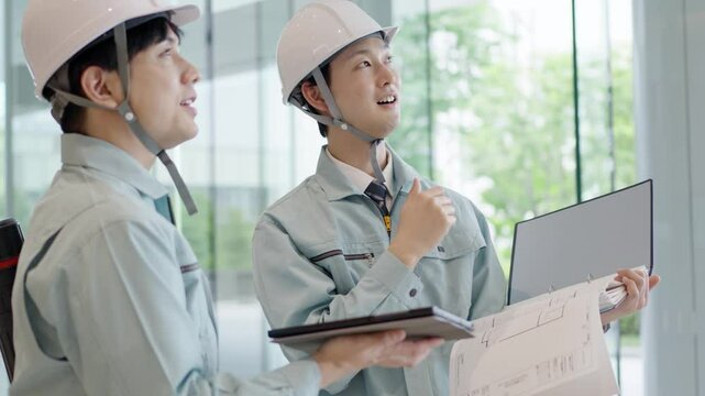 打ち合わせをする作業服を着た男性
