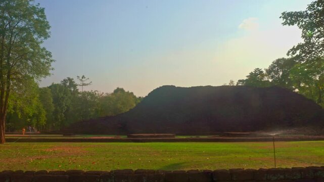The ruins of an old castle built with laterite bricks of the ancient city of Si Thep.
Ancient Angkor Temple Tower Amidst Park's Historic Stone Ruins and Towering Trees 
in Si Thep Historical Park