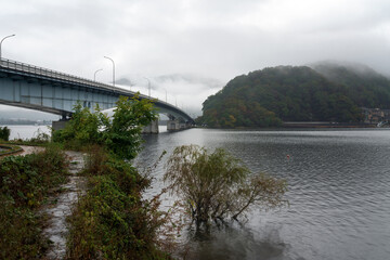 Kawaguchiko-ohashi Bridge over Lake Kawaguchi (Kawaguchi-ko, Estuary Lake) and Oike Park in the foreground on a cloudy autumn day, Fujikawaguchiko, Yamanashi Prefecture, Japan