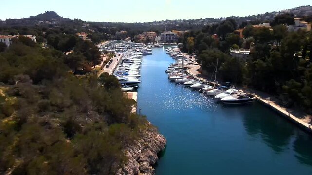 Enjoy stunning views of Santa Ponsa harbor featuring a variety of luxury yachts, surrounded by lush greenery and picturesque surroundings. Perfect for a relaxing getaway.