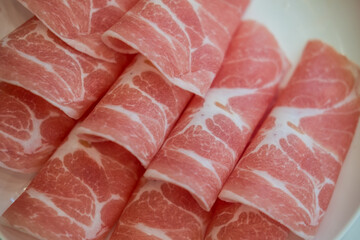 A close up of thinly sliced pork for hotpot, detailed marbling and fat. Pork platter