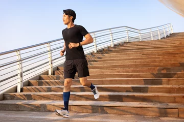 Young man running on the steps © Blue Jean Images