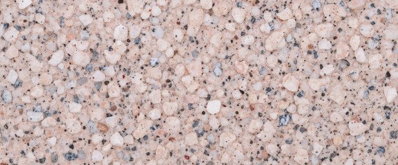Textured surface of light-colored aggregate material.