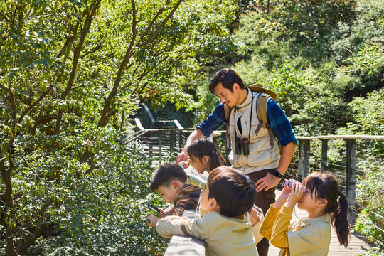 Happy teacher and kids hiking in the mountains