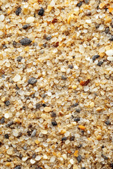 Close-up texture of multicolored sand grains, showcasing a variety of shapes and sizes.