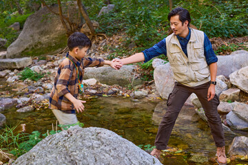 Teacher and kids having fun by the stream