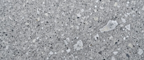 Close-up of a textured concrete surface with aggregate inclusions.