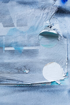 blue paint on a wall with torn paper surface