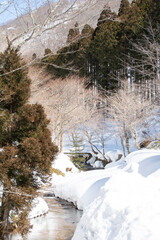 小川の流れる山の雪景色