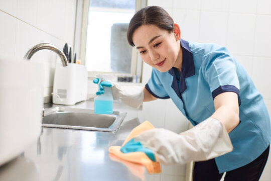 Cleaner tidying up the kitchen