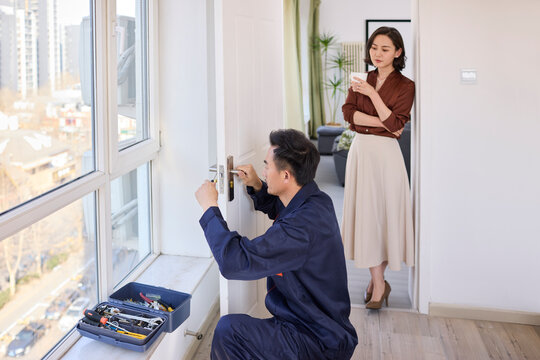 Handyman fixing the lock of the door