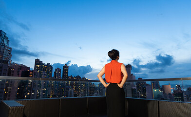 Businesswoman standing on the rooftop and thinking
