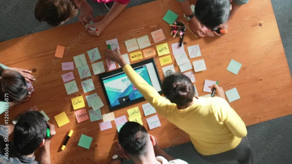 Poster top down view of programmer brainstorming and planning about web design while looking at tablet wire