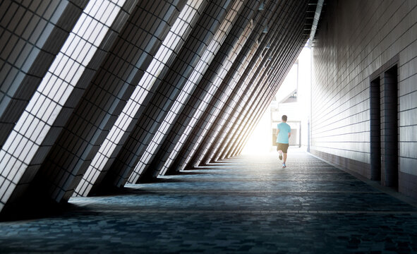 Teenage boy running through triangular corridor