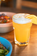 A refreshing glass of cold beer paired with a healthy meal, beautifully arranged on a wooden table.  The scene offers a perfect balance between a flavorful beer and health meal