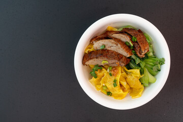 Dumplings with kale, Bok Choy (Chinese mustard greens) and roast duck on black table, Top view.