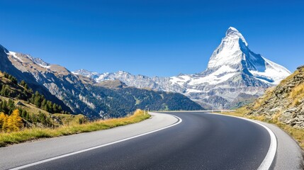 Scenic road winding through mountains under a clear blue sky.