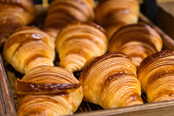 Trays of freshly baked croissants in a bakery. Bread making business