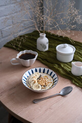 A stylish dining table with a charming vase, elegant dishes, bowl with oatmeal bowl. Cozy breakfast.