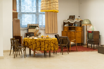 Retro style room with table, tablecloth, books, pastries