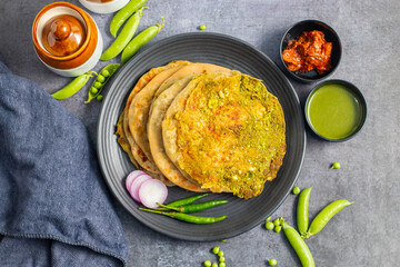 Matar paratha is a delicious Indian flatbread stuffed with spiced mashed green peas, cooked until golden and served with chutney.