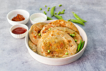 Matar paratha is a delicious Indian flatbread stuffed with spiced mashed green peas, cooked until golden and served with chutney.