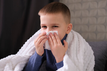 Sick student blows his nose and covers his nose with handkerchief with his eyes closed. Sick child...