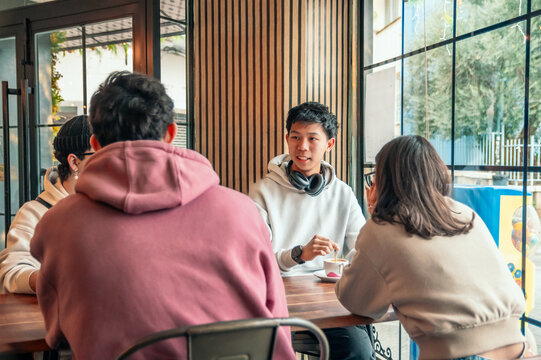 Diverse Millennials Chatting And Drinking Beverages At A Coffee Shop Table With Warm Social Interaction And Modern Vibes