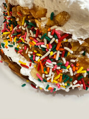 Waffle with rainbow sprinkles on whipped cream